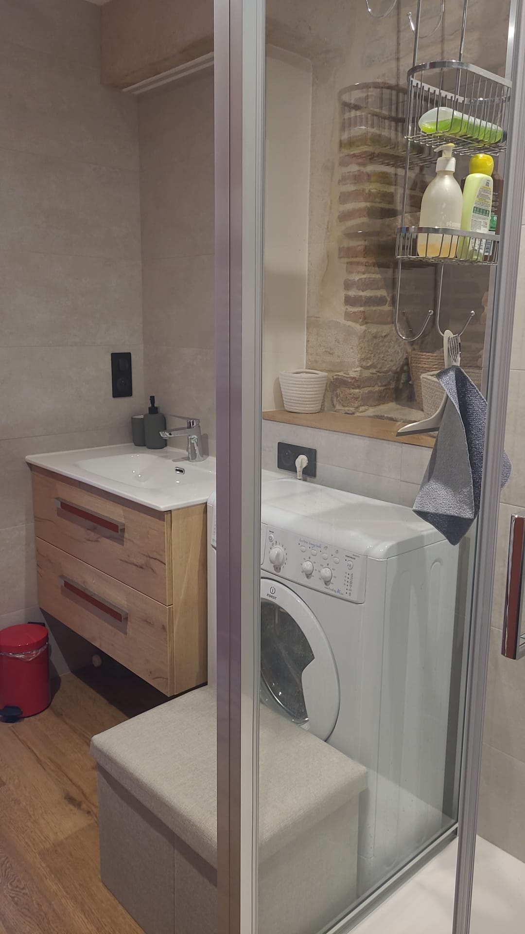 Salle de bain avec mur rouge et sèche-serviettes du gîte L'Ammonite